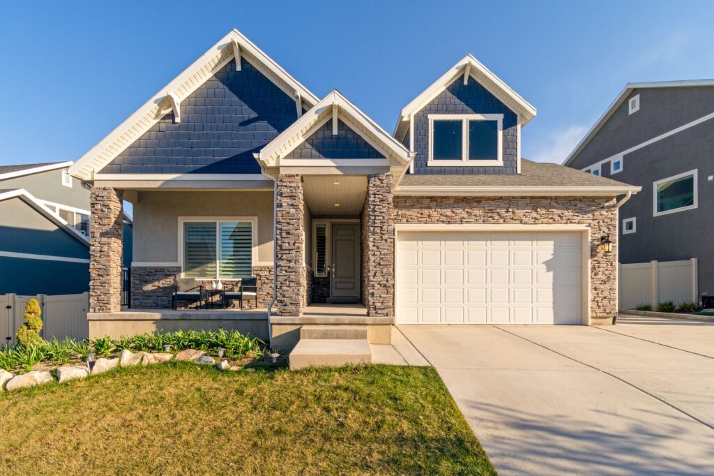 A single-family home with a stone facade and asphalt shingle roof, photographed in daylight on a maintained lawn.